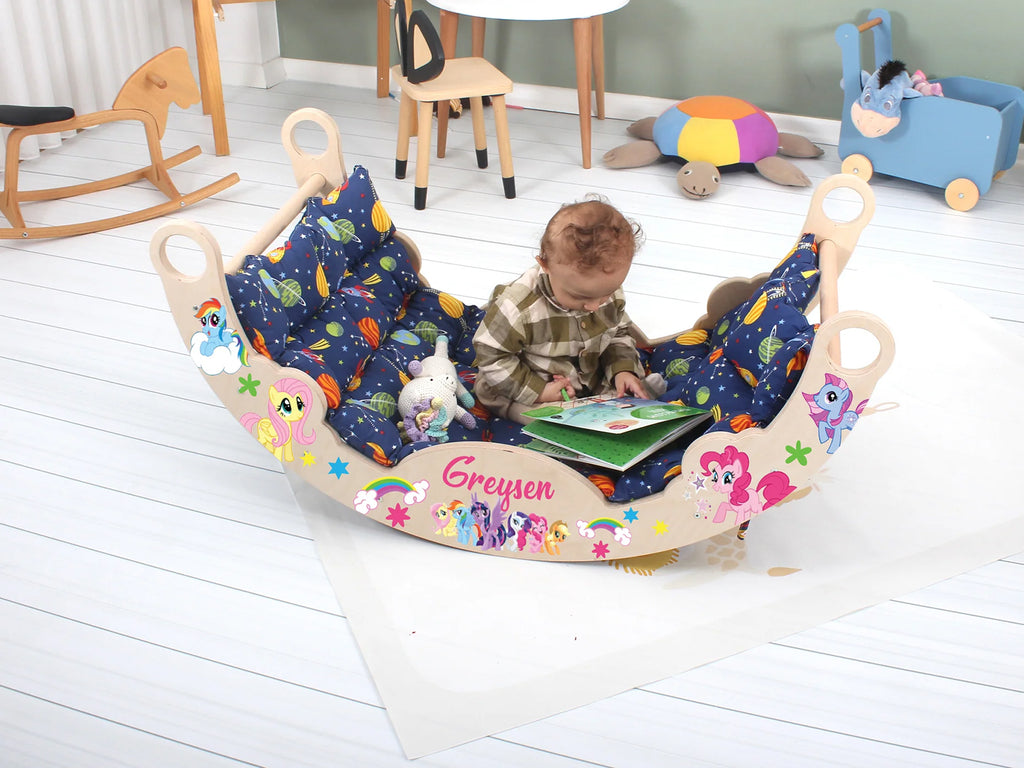 a baby sitting in a toy boat reading a book