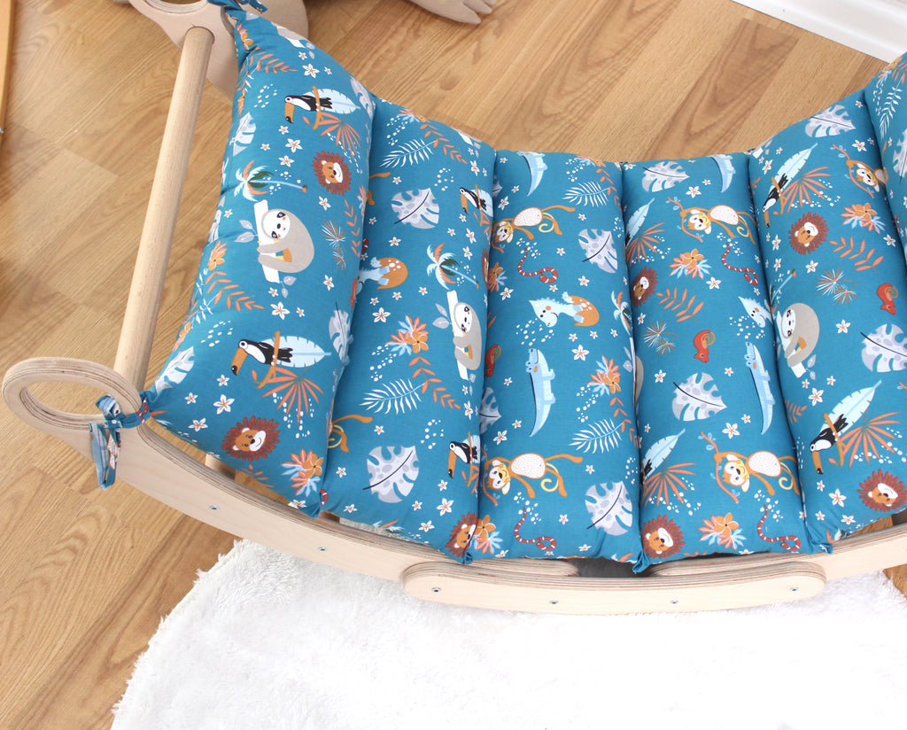 a child's rocking chair covered in a blue fabric