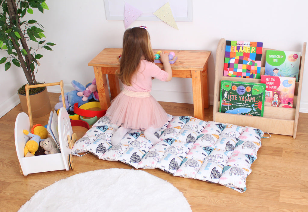 a little girl in a pink dress playing with toys